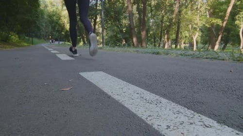 Closeup of Female Legs Run in Park Outdoors