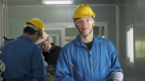 Asian mechanical technicians male workers working on milling and operating the machine in factory.