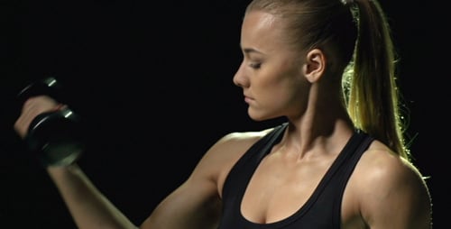 Athletic Woman Lifts Dumbbell in Workout Training