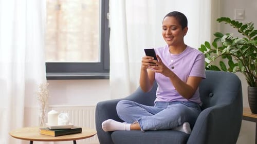 Woman Relaxing in Chair Using Smartphone