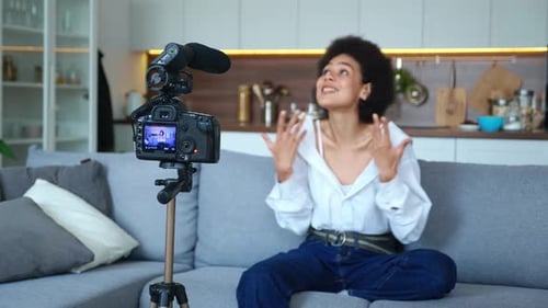 Young Woman Recording Video Blog on Couch at Home