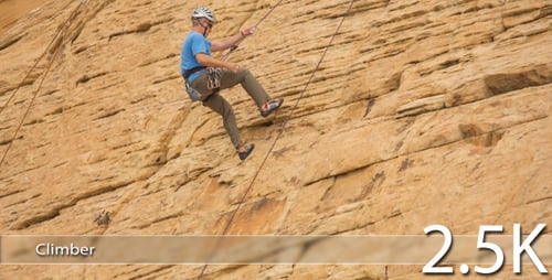 Man Climbing Steep Rock Face with Safety Gear