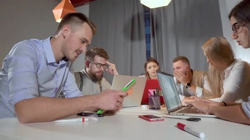 Office Workers Are Using Laptops and Tablets in Business Meeting
