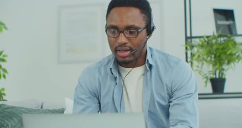 Young Adult with Headset Working Remotely From Home