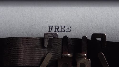 Typing word Free on retro typewriter. Close up.