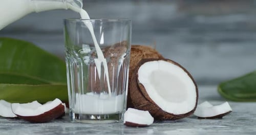 Coconut Milk Poured From a Jug Into a Glass