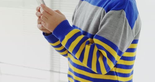 Smiling Boy Holds Smartphone and Looks at Camera