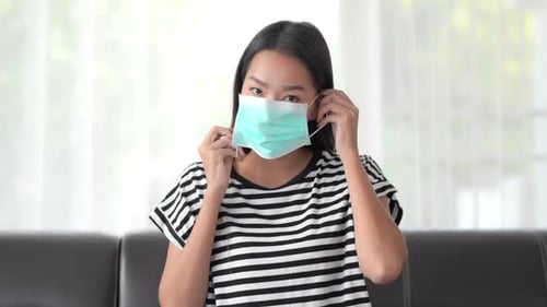 Young Adult Puts on a Medical Face Mask