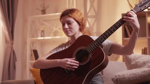 Woman Playing Guitar in Cozy Living Room