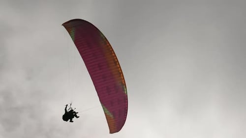 Die Leute versuchen Paragliding mit Fallschirmen gegen Wolken zu fliegen