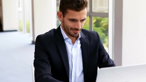 Successful Man Relaxing at Desk in Modern Office