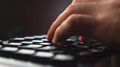 Detail View on Male Fingers Typing Text on Computer Keyboard