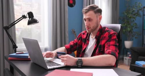 Man Shopping Online at Desk with Laptop and Card
