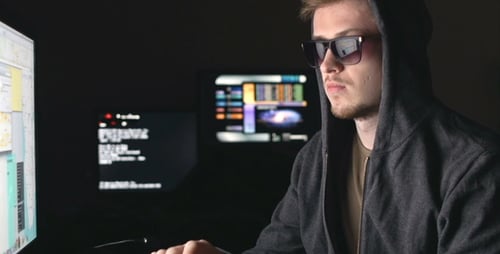 Man Types at Computer in Dark Room at Night