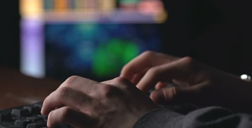 Hands Typing on Computer Keyboard at Night