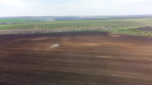 Luftbild eines Traktors, der auf einem Landfeld sprüht