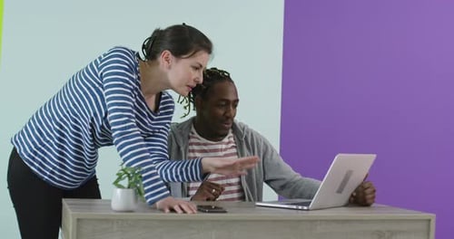 Positive Smiling Man and Woman Near Working Place with Laptop Cooperating in Office