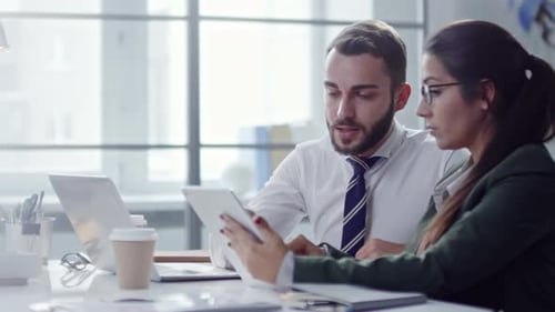 Colleagues Working with Tablet and Documents in Office