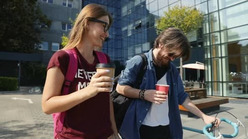 Young Adults Walk With Bicycle And Coffee
