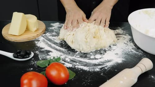 Hands of bakery chef kneading dough, making bread