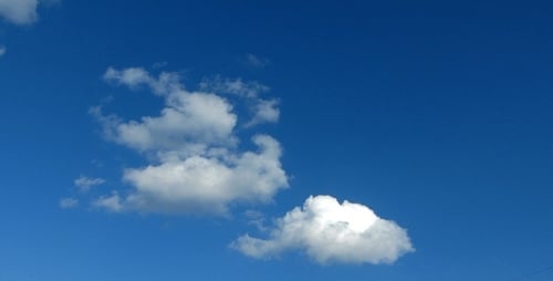 Fluffy Clouds Drifting Across a Clear Blue Sky