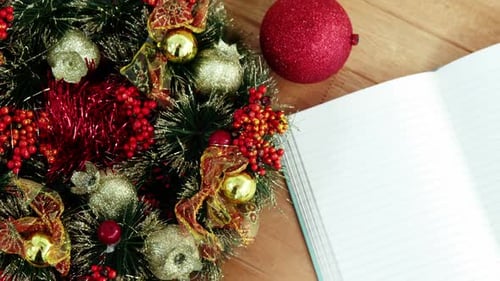 Close-up of coffee cup with christmas decoration and notebook