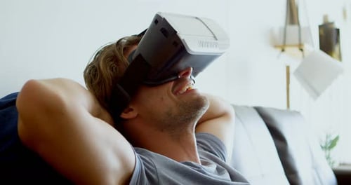 Man Relaxes on Sofa Using VR Headset