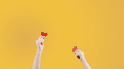 Female Blogger Hold in Hand Little Red Heart on Yellow Orange Background