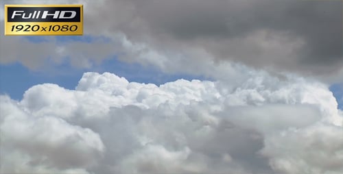 Fluffy White Clouds Drifting Across Bright Blue Sky
