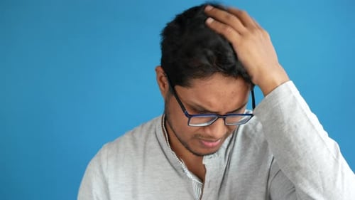 Young Adult Scratching His Head in Confusion