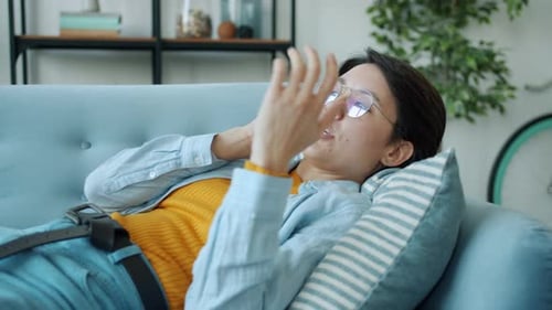 Woman Chatting on Phone Lying on Couch