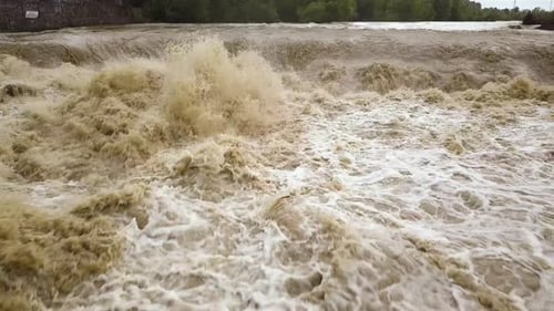 Aerial view of dirty river with muddy water in flooding period during heavy rains in spring.