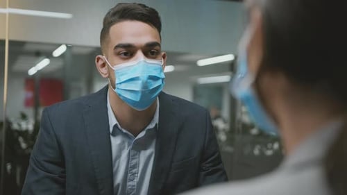 Man in Suit Talking in Office Wearing Mask