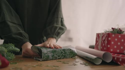 Wrapping Christmas Gifts on Wooden Table with Decorations