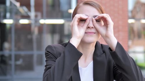 Businesswoman Mimics Binoculars with Hands Outside Office