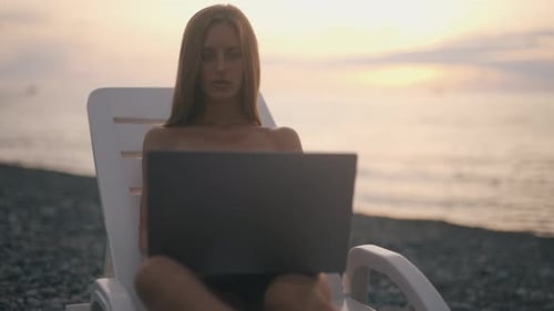 Eine Freelancerin arbeitet an einem Laptop in der Nähe von Meer