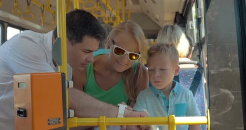 Family Looks at Smart Watch on City Bus