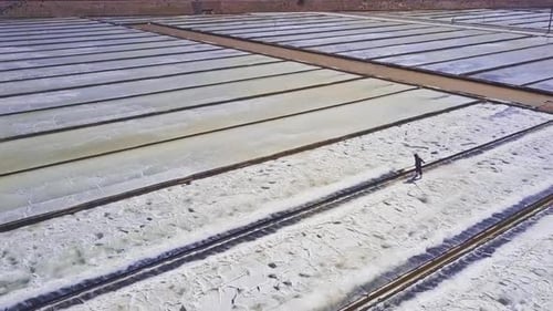 Man Gathers Salt with Shovel From Side To Centre