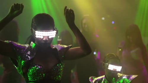 Group of People Dance in Disco Night Club to the Beat of Music From DJ on Stage