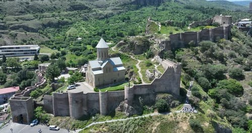 Aerial view of Tbilisi old town buildings and Narikala fortress landmark on hill
