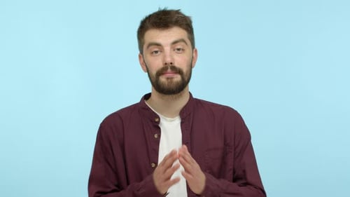 Zeitlupe eines süßen bärtigen Mannes in Freizeitkleidung, der um Gefallen bittet, bitte sagt und Händchen hält