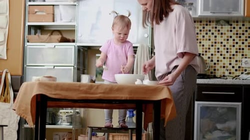 Mother and Daughter Baking Together in Kitchen