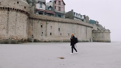 Wide Shot Happy Excited Tourist Man with Backpack Walking Close Near Epic Mont Saint Michel Castle
