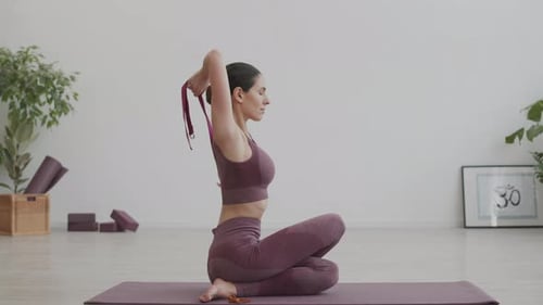 Woman Practicing Yoga with Strap Indoors