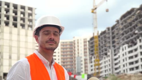 Portrait of a Successful Young Engineer, Architect, Builder, Businessman, Wearing a White Helmet, in