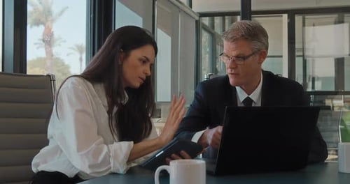Nahaufnahme von zwei Kollegen, die über einen Computer über ein neues Projekt diskutieren, Zeitlupe