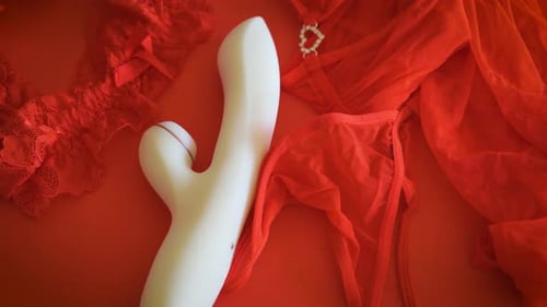 White Vibrator Sex Toy on Red Background with Underwear