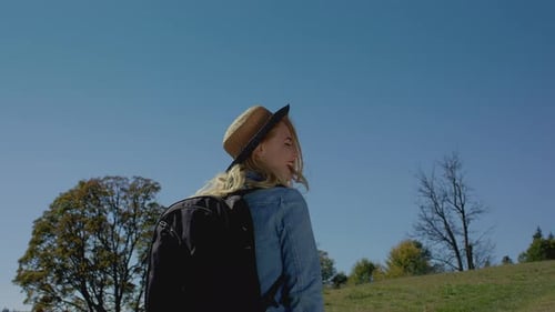 Smiling Woman Hikes in Rural Setting on Sunny Day