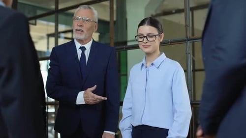 Mature Boss Introducing New Female Colleague in Office, Coworkers Shaking Hands