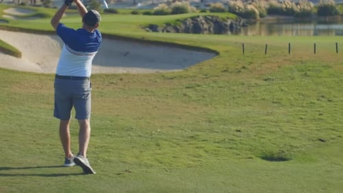 Man Swinging Golf Club on Beautiful Golf Course